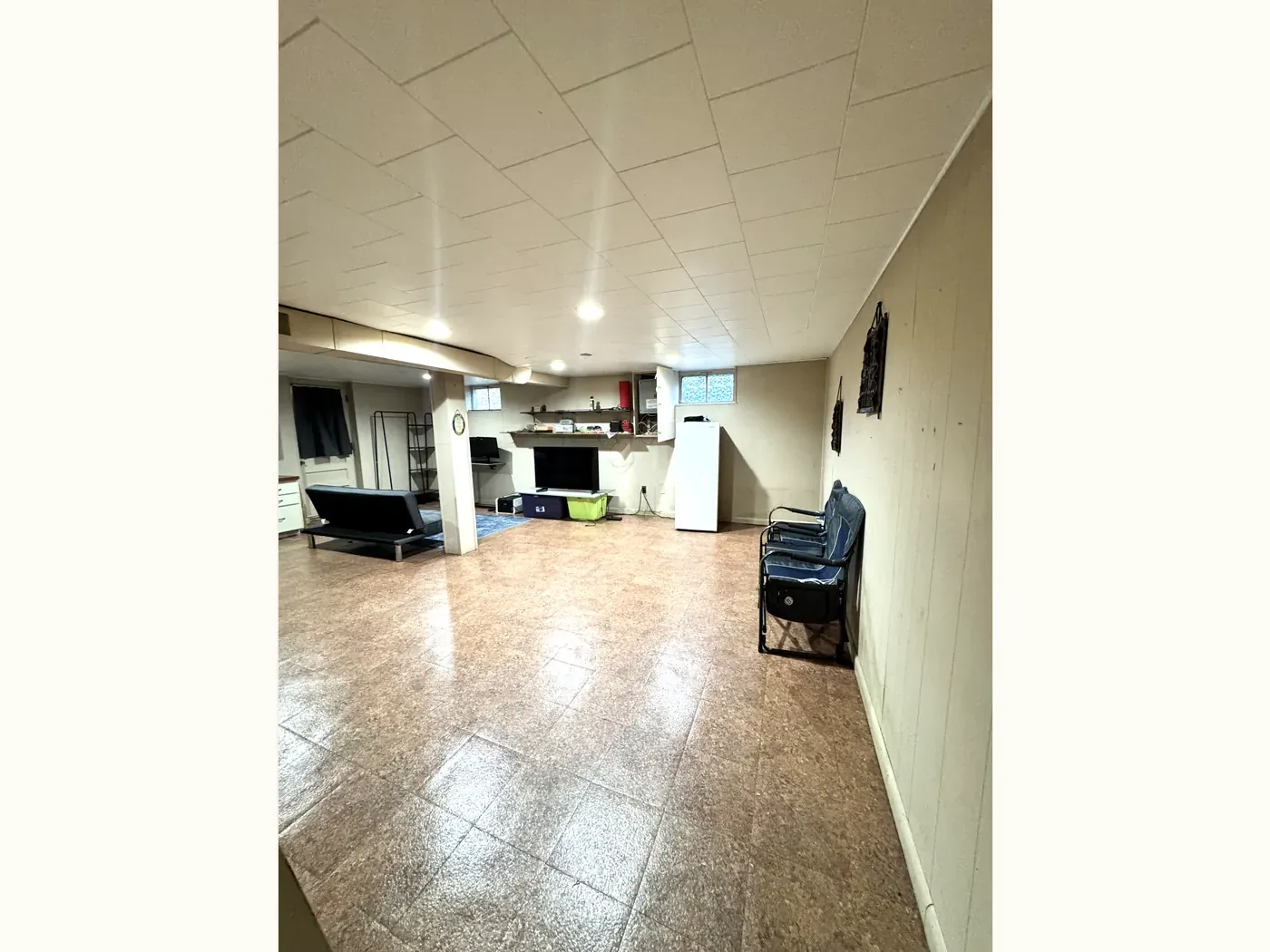 The same lower level cleared, with open floor and a tidy media wall